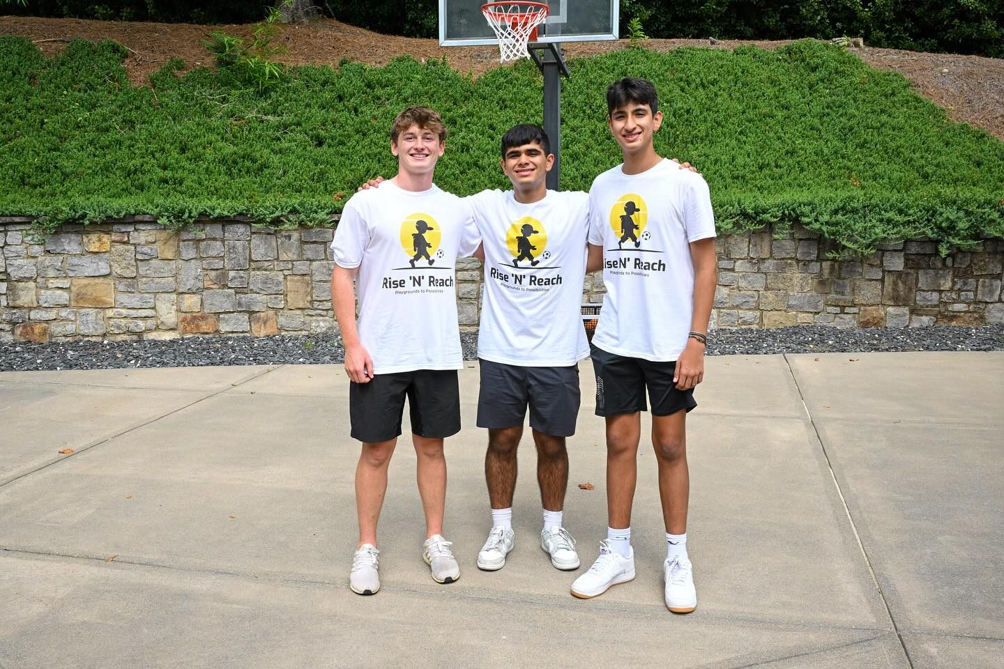 Rise 'N' Reach founders in team shirts at the organization's first fundraiser in August 2025