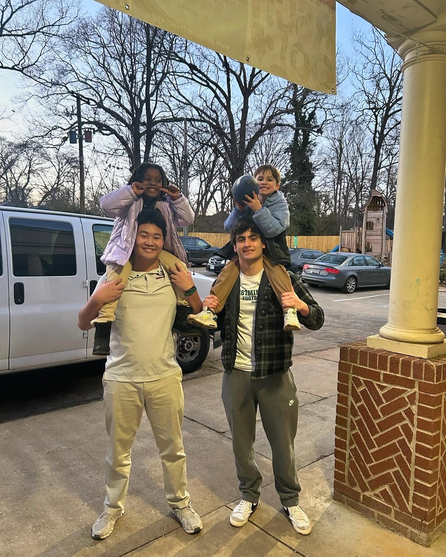 Teen volunteers posing together beside a van before a session